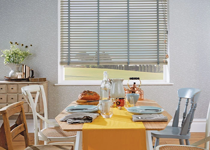 Venetian blinds filtering natural light over a breakfast table